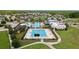 Aerial view of a community pool with a long lap pool, splashpad with palm trees, and a covered seating area at 22489 Storybook Cabin Way, Land O Lakes, FL 34637