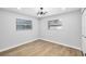 Cozy bedroom with wood floors features modern lighting, and two windows for ample natural light at 2306 S San Jose Cir, Tampa, FL 33629