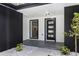 Modern front porch with sleek black door, side window, tiled floor, and updated landscape at 2306 S San Jose Cir, Tampa, FL 33629