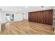 Open living space with wood-look tile flooring, wooden accent wall, and sliding door to backyard pool at 2306 S San Jose Cir, Tampa, FL 33629