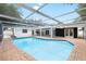 Sparkling pool with brick surround features a screened enclosure for enjoying year-round outdoor living at 2306 S San Jose Cir, Tampa, FL 33629