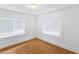 Bright bedroom with wood floors features white walls and trim and two windows with mini-blinds at 2312 Highland S St, St Petersburg, FL 33705