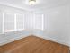 Bright bedroom features white walls and trim and two windows with mini-blinds and wood floors at 2312 Highland S St, St Petersburg, FL 33705