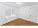 Bright bedroom with wood floors features white walls and trim, and one window with mini-blinds at 2312 Highland S St, St Petersburg, FL 33705