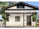 Charming home exterior features a covered porch with pergola, a black front door and white picket fence at 2315 E 12Th Ave, Tampa, FL 33605