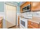 Kitchen featuring white appliances, wooden cabinetry, and stainless steel microwave at 2630 Pearce Dr # 108, Clearwater, FL 33764