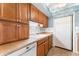 Well-lit kitchen with wooden cabinets, white appliances, and a charming blue accent wall at 2630 Pearce Dr # 108, Clearwater, FL 33764