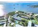 Aerial image featuring a waterfront community with a pool, tennis court, and lush trees at 2700 Bayshore Blvd # 11308, Dunedin, FL 34698