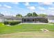 Expansive lawn area with meticulous landscaping and an enclosed screen patio at 2900 Sandpiper Pl, Clearwater, FL 33762