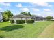 Well-manicured lawn with lush green grass, neatly trimmed hedges and a peek at the screened in lanai at 2900 Sandpiper Pl, Clearwater, FL 33762