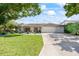 Charming single-story home featuring a tile roof, manicured lawn, and lush landscaping at 2900 Sandpiper Pl, Clearwater, FL 33762