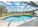 Inviting screened-in pool area with a hot tub and a scenic view of the golf course at 2900 Sandpiper Pl, Clearwater, FL 33762