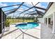 Relaxing screened-in pool area with a hot tub, lush greenery, and golf course views at 2900 Sandpiper Pl, Clearwater, FL 33762