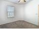 Small bedroom with light gray carpet, fan, and window at 31771 Blue Passing Loop, Wesley Chapel, FL 33545