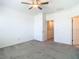 Neutral carpeted bedroom with ceiling fan and connecting hallway and staircase at 31771 Blue Passing Loop, Wesley Chapel, FL 33545