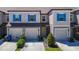 Beautiful townhome featuring a garage, well-manicured landscaping, and modern design at 31771 Blue Passing Loop, Wesley Chapel, FL 33545