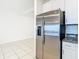 Modern kitchen featuring stainless steel refrigerator, white cabinets and tiled flooring at 31771 Blue Passing Loop, Wesley Chapel, FL 33545