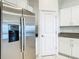 Modern kitchen with stainless steel refrigerator and white cabinetry at 31771 Blue Passing Loop, Wesley Chapel, FL 33545