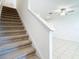 Carpeted staircase leads to a bright living space with neutral walls and tile flooring at 31771 Blue Passing Loop, Wesley Chapel, FL 33545