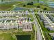 Aerial view of a residential neighborhood with houses and green spaces by a pond at 35100 Brackett Bnd, Zephyrhills, FL 33541