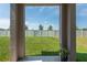 Covered back porch area overlooking a spacious backyard with a white vinyl fence at 35100 Brackett Bnd, Zephyrhills, FL 33541