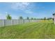 Spacious, well-maintained backyard with lush green grass and a pristine white fence at 35100 Brackett Bnd, Zephyrhills, FL 33541
