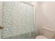 Bright bathroom showing a toilet next to a bath/shower featuring a bright and fun floral shower curtain at 35100 Brackett Bnd, Zephyrhills, FL 33541