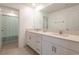 Bright bathroom with double vanity, modern countertops, and a bath/shower featuring a floral shower curtain at 35100 Brackett Bnd, Zephyrhills, FL 33541