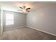Bright bedroom featuring a ceiling fan and window, complete with neutral walls and carpeted floors at 35100 Brackett Bnd, Zephyrhills, FL 33541