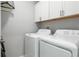 Well-lit laundry room with modern appliances and storage cabinets at 35100 Brackett Bnd, Zephyrhills, FL 33541