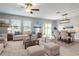 Bright living and dining area with neutral decor, large windows, and sliding glass door access to yard at 35100 Brackett Bnd, Zephyrhills, FL 33541