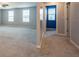 Bright, open-concept living room with carpet, three large windows, and neutral color palette for a modern aesthetic at 35100 Brackett Bnd, Zephyrhills, FL 33541