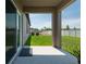 Covered patio with concrete floor, sliding glass door, and view of the grassy backyard and white fence at 35100 Brackett Bnd, Zephyrhills, FL 33541