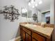 Bathroom sink vanity with decorative lighting, ornate mirror, and beige countertops at 3544 Brook Crossing Dr, Brandon, FL 33511