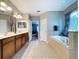 The bathroom features dual sinks, a garden tub, and a large window for natural light at 3544 Brook Crossing Dr, Brandon, FL 33511