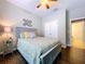 Bedroom with wood floors, fan, and a decorative leaf accent wall at 3544 Brook Crossing Dr, Brandon, FL 33511