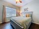 Bright bedroom featuring a large window, comfortable bed, wood floors, and leaf wall art at 3544 Brook Crossing Dr, Brandon, FL 33511