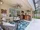 Outdoor patio features ceiling fans, bar area, TV, and cozy seating with tropical-themed decor at 3544 Brook Crossing Dr, Brandon, FL 33511