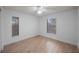 Bright bedroom featuring light wood floors and two large windows at 3705 Simpson Ct, Palm Harbor, FL 34684