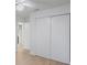 Hallway with light wood floors and large, bright white sliding closet doors at 3705 Simpson Ct, Palm Harbor, FL 34684