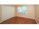 Comfortable bedroom with wood floors, neutral walls, closet, and a bright window at 37712 Aaralyn Rd, Zephyrhills, FL 33542