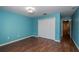 This bedroom features striking blue walls, hardwood floors, closet, and ample natural light at 37712 Aaralyn Rd, Zephyrhills, FL 33542