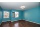 Charming bedroom featuring laminated wood floors, and ample natural light from two windows at 37712 Aaralyn Rd, Zephyrhills, FL 33542