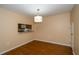 Bright dining area featuring wood floors and a pass-through to the kitchen at 37712 Aaralyn Rd, Zephyrhills, FL 33542