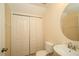 A compact yet functional half bathroom boasts a stylish round mirror and a bi-fold closet at 37712 Aaralyn Rd, Zephyrhills, FL 33542