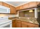 Well-lit kitchen featuring granite counters, white appliances, and an open view to an additional room at 37712 Aaralyn Rd, Zephyrhills, FL 33542