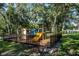 Community playground with various climbing and sliding structures surrounded by mature trees at 37712 Aaralyn Rd, Zephyrhills, FL 33542