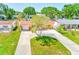 Aerial view of a well-maintained home with a spacious front yard and curved driveway in a green neighborhood at 4360 82Nd N Ave, Pinellas Park, FL 33781