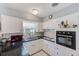 Close-up of kitchen featuring white cabinets, black countertops, and stainless steel sink with charming decor at 4360 82Nd N Ave, Pinellas Park, FL 33781