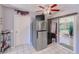 Functional kitchen featuring a stainless steel refrigerator, white tile floors, and access to the outdoor patio at 4360 82Nd N Ave, Pinellas Park, FL 33781